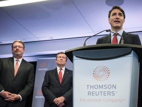 Prime Minister Justin Trudeau addresses an audience of media and stakeholders as President and CEO of Thomson Reuters James Smith, left, Toronto Mayor John Tory look on in Toronto Friday at the launch of Thomson Reuters’ new technology centre.