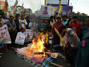 Indian members of the Congress Party shout slogans and burn an effigy of Prime Minister Narendra Modi during a protest against demonetisation in Siliguri on November 28, 2016.