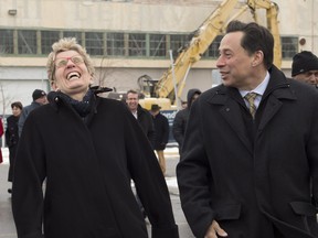 Ontario Premier Kathleen Wynne and Minister of Economic Development and Growth Brad Duguid share a laugh after a groundbreaking ceremony for the Centennial College Downsview Aerospace Campus in Toronto on Monday November 21, 2016