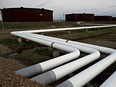 Pipelines run toward oil storage tanks stand at the Enbridge Inc.