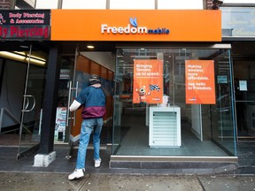 A man enters the store at the new rebranding sign of Freedom Mobile in Toronto