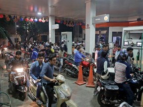Indians crowd a gas station, one of the few places still accepting the high denomination 1000 and 500 currency notes, in New Delhi, India, Tuesday, Nov. 8, 2016.