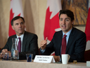 Prime Minister Trudeau takes part in a roundtable in Toronto as Minister of Finance Bill Morneau looks on. 