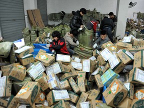 Chinese workers sort through boxes of goods at a delivery company in Lin'an, east China's Zhejiang province on November 11, 2016.