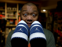 Toddy Flores, poses with an Air Jordan One Plus sneaker, a sample that is numbered at 0 of 0 and has a full coloured jumper, making it a rare pair