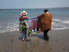 Shamans perform a good luck ritual for Donald Trump using a poster of him at the beach in Lima, Peru, on Nov. 7, 2016.