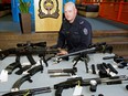 Sgt. Grant Jongejan (Edmonton Police Service Bomb Detail) at police headquarters with some of the weapons confiscated with search warrants earlier this year.