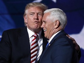 Republican presidential Candidate Donald Trump gives his running mate, Gov. Mike Pence of Indiana, a kiss as they shake hands after Pence's acceptance speech to be the vice presidential nominee during the third day session of the Republican National Convention in Cleveland, on July 20, 2016