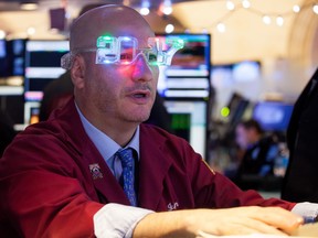 A trader wearing 2017 glasses works on the floor of the New York Stock Exchange on Friday.