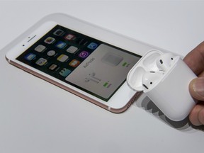 An attendee holds the Apple AirPods next to the iPhone 7s at the iPhone 7 event in San Francisco.