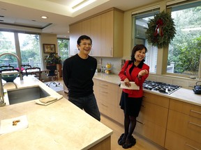 Janie Lee, right, a residential specialist with John L. Scott Real Estate, shares a laugh in the kitchen of a home for sale to she was showing to her client, Hongbin Wei, of Beijing, China, Thursday, Dec. 18, 2014, in Medina, Wash., near Seattle.