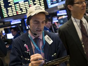 A trader wearing a 'Dow 20,000' hat works on the floor of the New York Stock Exchange in New York City. The Dow Jones Industrial Average continues to approach the 20,000 mark.
