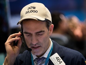 A trader wears a 'Dow 20,000' hat on the floor of the New York Stock Exchange Tuesday, the day the index closed just 25 points shy of the mark.