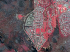 This photo provided by DigitalGlobe shows a satellite image of Fort McMurray in Alberta, Canada, on May 5, 2016, in the aftermath of a massive wildfire. The bright red areas represent land untouched by the fire, while the area destroyed by the blaze shows up as black and gray.