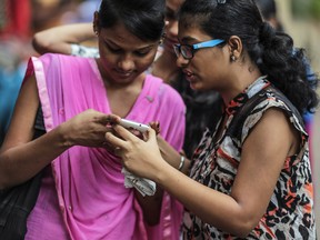 Students look at a their smartphone in Mumbai, India.