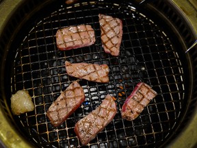 Slices of Kampo Wagyu beef steak sit on a grill at the Kounosuke grilled-beef restaurant owned by Seikou Sekimura in Kurihara, Miyagi, Japan, on Thursday, Nov. 24, 2016.