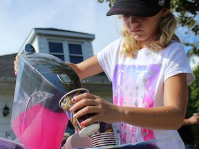 Seven-year old Lauren Ashcroft pours pink lemonade into a cup for a customer, while selling lemonade in Belleville, Ont. to support a local charity. Helping your children set up their own business is about more than letting them earn money. It teaches them about responsibility, hard work and the value of money.
