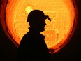 A worker passes red hot furnace in the steel making shop at the OAO Izhstal steel plant, operated by OAO Mechel, in Izhevsk, Russia.