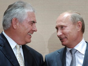 Russian Prime Minister Vladimir Putin, right, and Rex Tillerson smile during a signing ceremony in the Black Sea resort of Sochi, Russia.