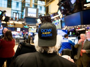 A trader wearing a "DOW ALMOST 20,000" hat works on the floor of the New York Stock Exchange (NYSE) in New York, U.S., on Wednesday, Dec. 21, 2016. U.S. stocks fluctuated with the Dow Jones industrial Average failing to make progress toward 20,000 as oil erased gains and a rally in the dollar faltered in light trading ahead of the holidays.