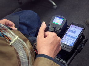Tecla's interface being used for an iPhone connected to a wheelchair.