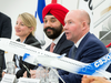 Bombardier President and CEO Alain Bellemare, right responds to a question as Heritage Minister Melanie Joly, left, and Innovation Minister Navdeep Bains look on.