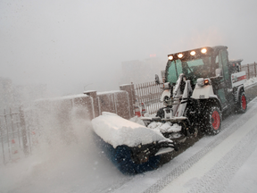 A snow plow clears snow on the pedestrian walkway of the Brooklyn Bridge, February 9, 2017 in New York City.