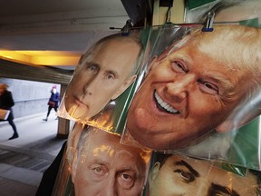 In this Monday, Feb. 20, 2017 photo face masks depicting Russian President Vladimir Putin and US President Donald Trump hang on sale at a souvenir street shop in St.Petersburg, Russia.