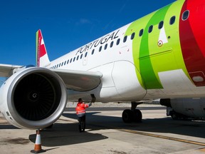 An engineer operates the fuel access panel of an Airbus A319-11 aircraft operated by TAP Portugal.