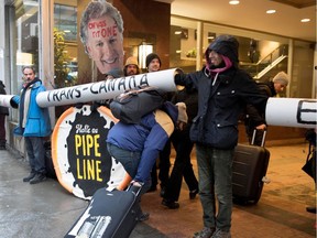 MONTREAL, QUE.: MARCH 28, 2017-- Greenpeace members raise their cardboard pipeline for hotel guests to get by as they protest outside The National Energy Board meetings in Montreal on Tuesday March 28, 2017.