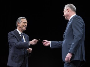 Howard Schultz hands over the key to the original Starbucks store to President and Chief Operating Officer Kevin Johnson during the Starbucks annual meeting on March 22, 2017.