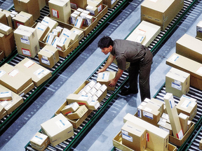 A driver sorts packages in the hub at a United Parcel Service facility. A study has found that Canada Customs in more likely to collect taxes and duties on parcels imported via a service like UPS than parcels sent through the mail system.