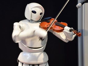 A violin playing robot, a series of humanoid robots from Toyota Partner Robot, is displayed at a robot event for children in Tokyo on August 9, 2015.