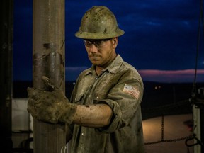 Scott Berreth, a derrick hand for Raven Drilling, works on an oil rig drilling into the Bakken shale formation.