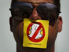 A demonstrator stands for a photograph with a "#evictsnapchat" sticker over his mouth while protesting outside the Snap Inc. office in the Venice neighborhood of Los Angeles, California.