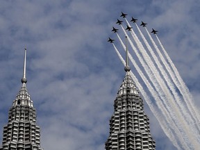 The South Korean Air Force "Black Eagles" aerobatic team flies past Malaysia's Petronas Twin Towers in Kuala Lumpur on March 29, 2017.