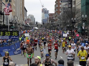 In this Monday, April 17, 2017, file photo, runners head to the finish line in the 121st Boston Marathon in Boston.
