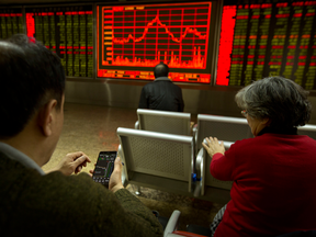 Investors check stock prices in a brokerage house in Beijing.