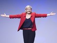In this April 17, 2017 file photo, far-right candidate for the presidential election Marine Le Pen gestures as she arrives for a campaign meeting in Paris.