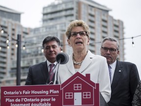 Ontario Premier Kathleen Wynne, centre, is joined by Ontario Finance Minister Charles Sousa, left, and Ontario Housing Minister Chris Ballard in Toronto on Thursday to announce Ontario's Fair Housing Plan.
