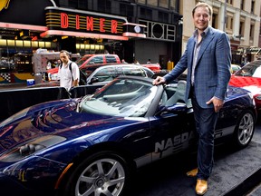 Elon Musk, CEO of Tesla Motors, stands with a Tesla Roadster electric car outside the Nasdaq in New York, in 2010 after its IPO.