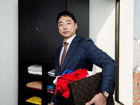Shin Sakane with a prototype of the Laundroid, his laundry-folding robot, in Tokyo.