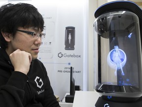 Hikari Azuma, the first character for the Gatebox virtual home robot, is displayed inside the home robot device at the Vinclu Inc. office in Tokyo, along with Minori Takechi, CEO of Vinclu Inc.