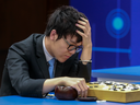 Chinese Go player Ke Jie reacts as he plays a match against Google's artificial intelligence program, AlphaGo, during the Future of Go Summit in Wuzhen