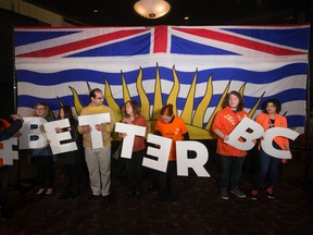 A volunteer arranges supporters holding letters to spell out 'Better BC' before an NDP campaign rally with Leader John Horgan in Vancouver, B.C., on Sunday April 23, 2017.