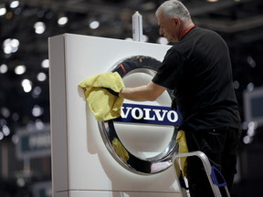 A worker cleans a Volvo logo at the Geneva International Motor Show.