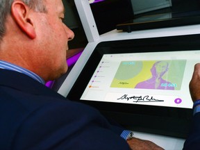 Bank of Canada Governor Stephen Poloz plays on a console that lets one design their own play bank note as he tours the new Bank of Canada Museum in Ottawa on Tuesday, June 20, 2017. THE CANADIAN PRESS/Sean Kilpatrick