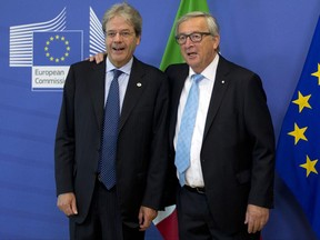Italian Prime Minister Paolo Gentiloni, left, is greeted by European Commission President Jean-Claude Juncker prior to a meeting at EU headquarters in Brussels on Thursday, June 22, 2017. EU heads of state meet for a two-day summit beginning Thursday to discuss Brexit negotiations and security. (AP Photo/Virginia Mayo)
