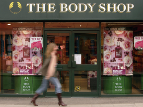 A woman walks past The Body Shop store window in London, England.