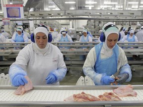 FILE - In this March 21, 2017 file photo, workers prep poultry at the meatpacking company JBS in Lapa, Brazil. In a major blow to Brazil, the United States on Thursday, June 22, 2017 announced the immediate suspension of all imports of beef products from Latin America's largest nation because of safety concerns. (AP Photo/Eraldo Peres, File)